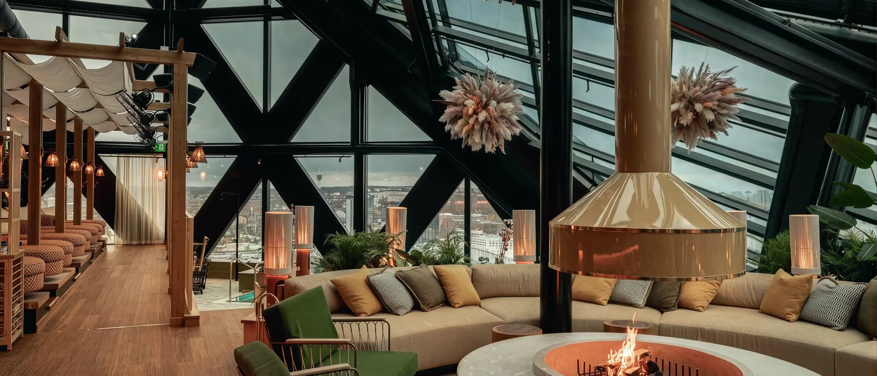 Loungen på Jacy'z Hotel: soffor och öppen eld under glastaket, med Göteborg utanför